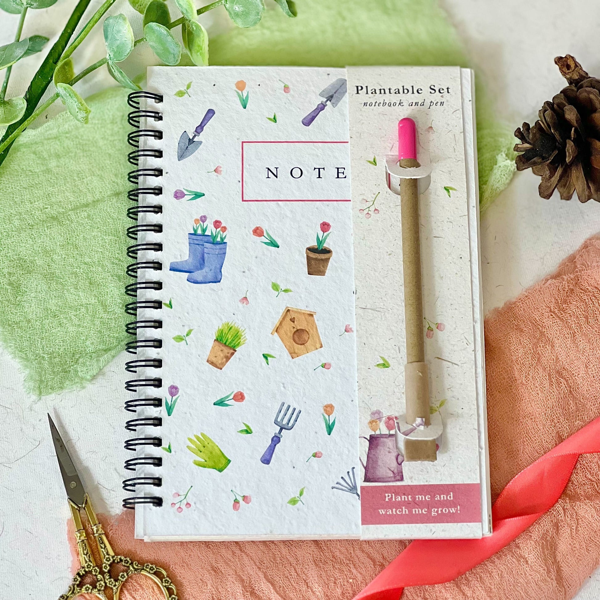 Eco-friendly notebook & pen set with a plantable seed paper cover featuring a floral gardening design.